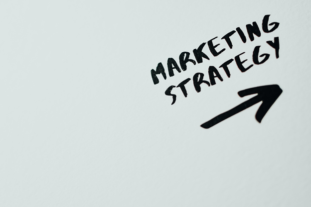 black writing on a whiteboard that reads "marketing strategy" with a black arrow pointing up just below it