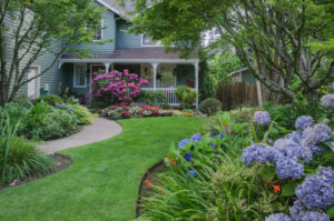 beautifully landscaped, older two story home with blue paint and a beautifully landscaped yard with hydrangeas. Used to accompany a blog post about marketing for landscapers