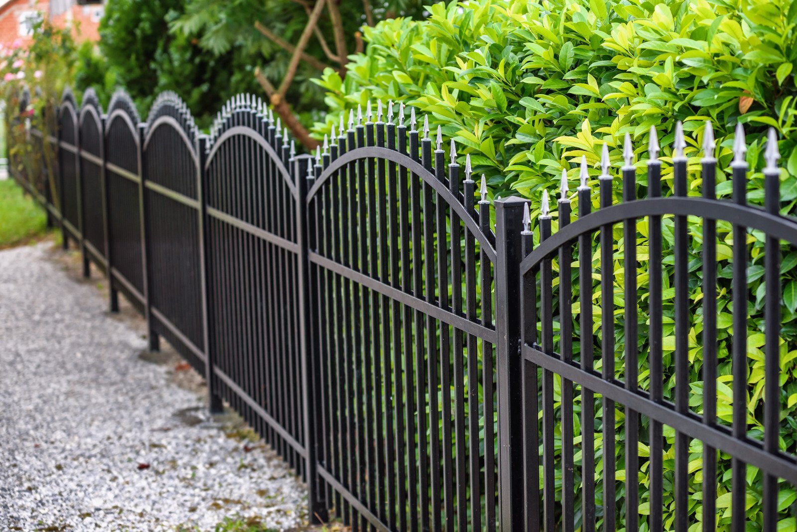 a beautifully landscaped yard with rod iron fencing