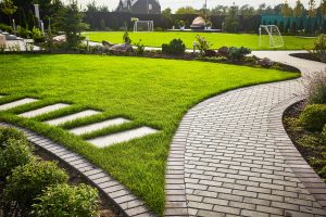 - Search Strategy Marketing Landscaping of the garden path curving through Lawn with green grass and walkway tiles